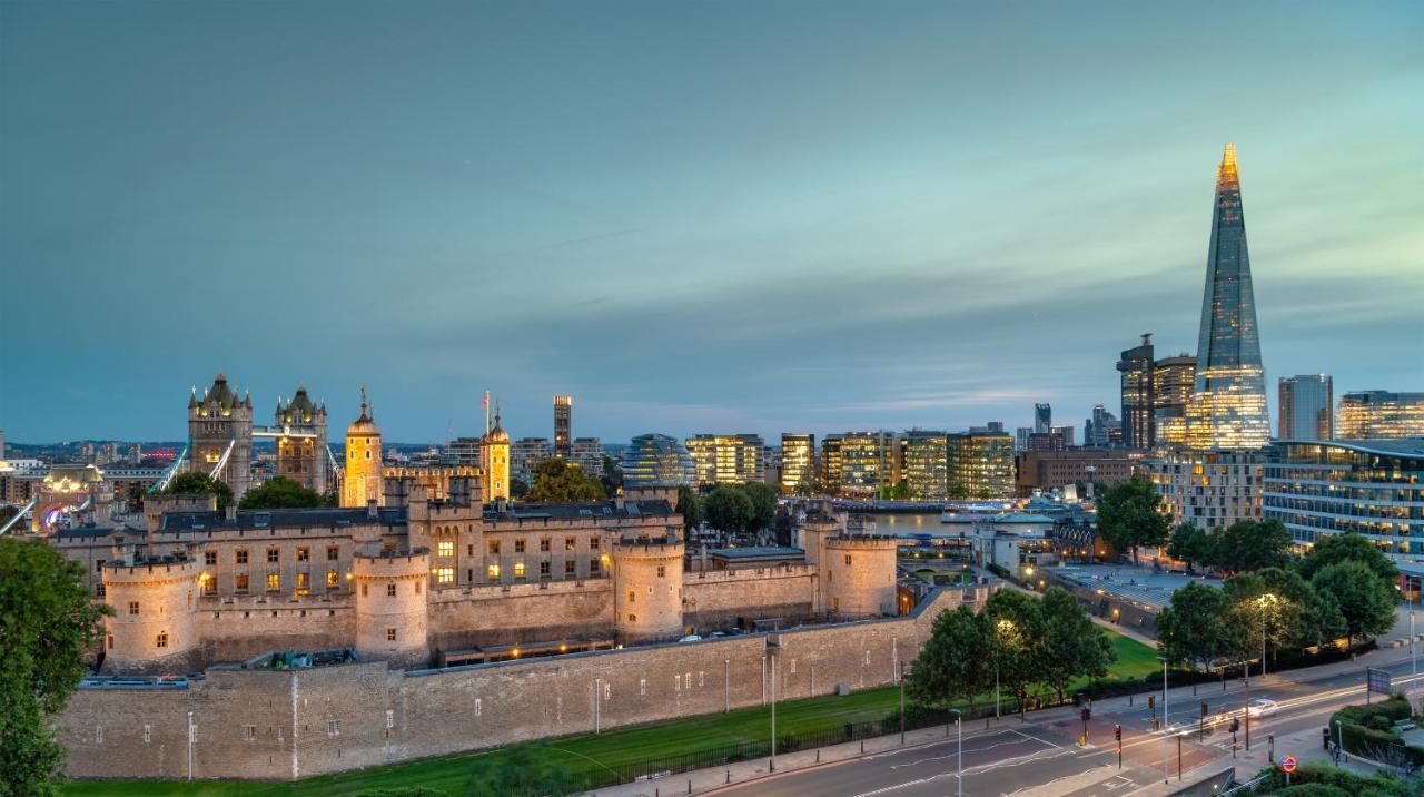 Tower Suites By Blue Orchid London Kültér fotó The photo shows a view of a historical site and modern skyline. In the foreground, there is a prominent historical building, likely a castle or fortress, featuring tall towers and a stone wall. This structure is set against a backdrop of contemporary