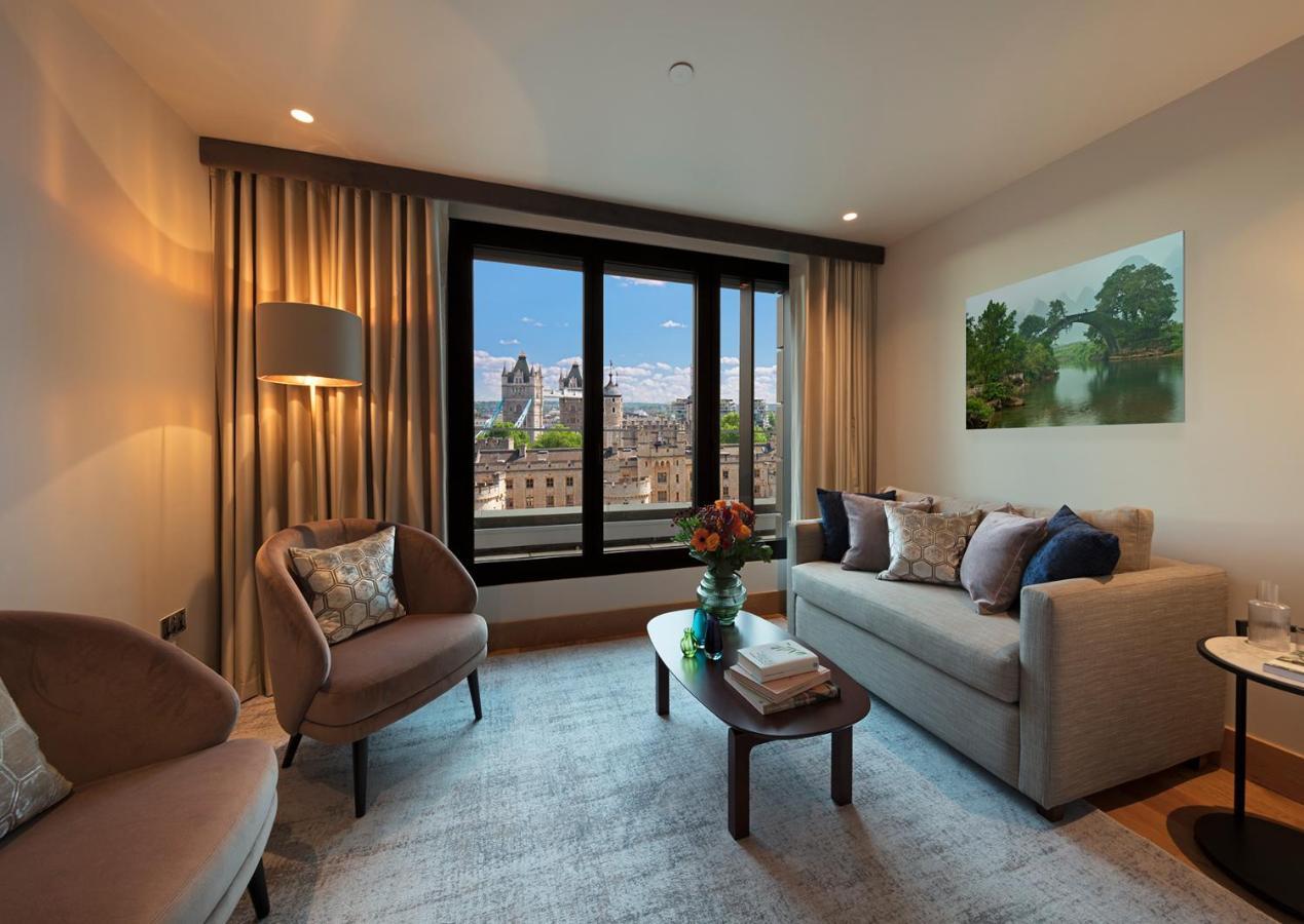 Tower Suites By Blue Orchid London Kültér fotó The photo depicts a modern living room with a contemporary design. It features two stylish, circular chairs and a comfortable sofa adorned with various decorative pillows. A small coffee table is positioned in front of the sofa, topped with books and