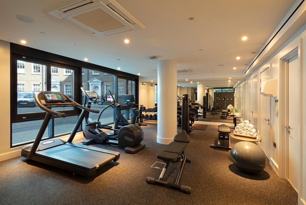 Tower Suites By Blue Orchid London Kültér fotó The photo shows a modern gym interior featuring various exercise equipment. On one side, there are several cardio machines, including treadmills and an elliptical. The gym has a spacious, bright feel with large windows allowing natural light to enter