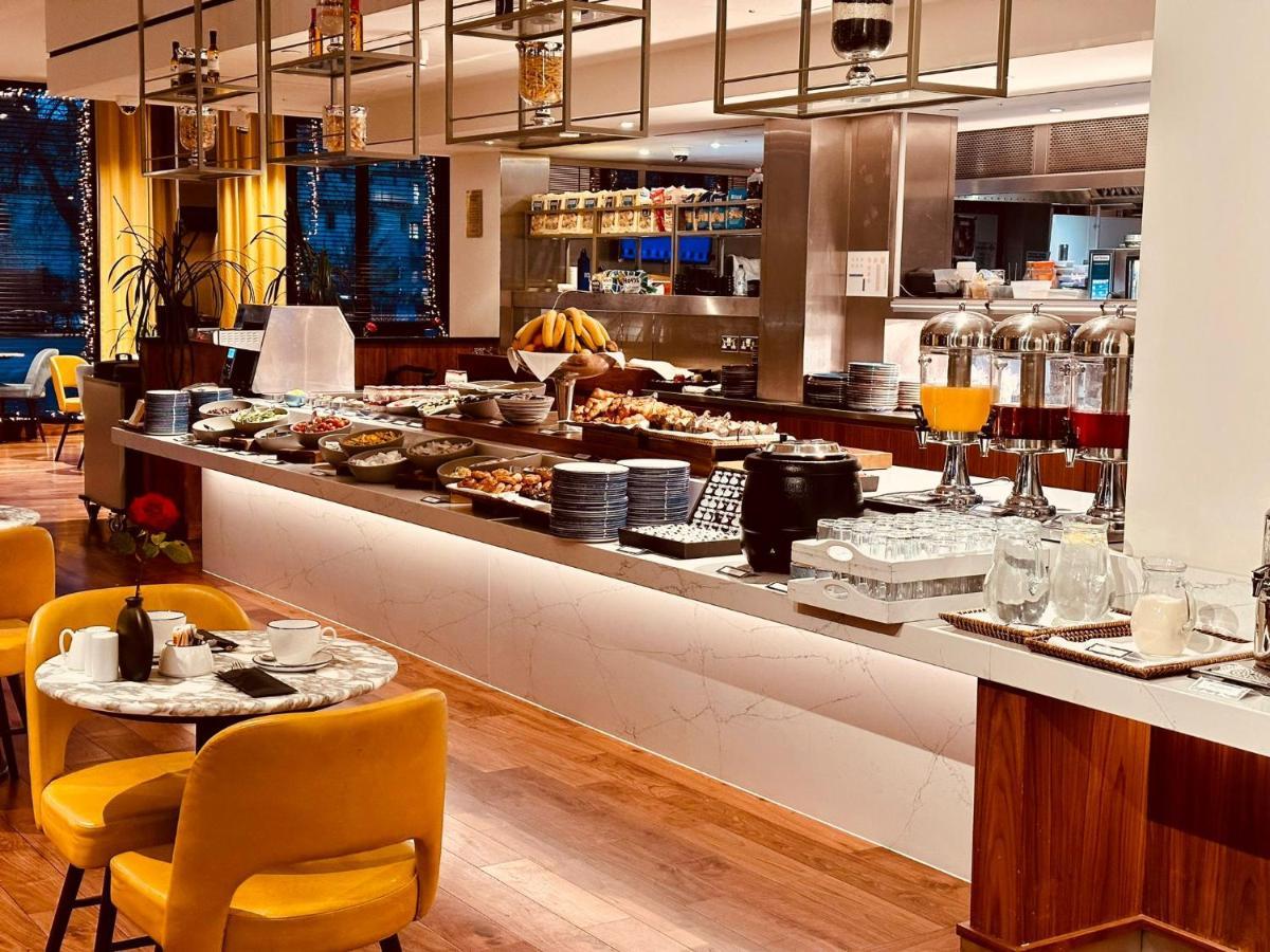 Tower Suites By Blue Orchid London Kültér fotó The photo depicts a modern buffet setting, featuring an array of food items displayed elegantly on a long countertop. There are various dishes, likely including pastries, fruits, and other breakfast items, arranged neatly. In the background, there ar